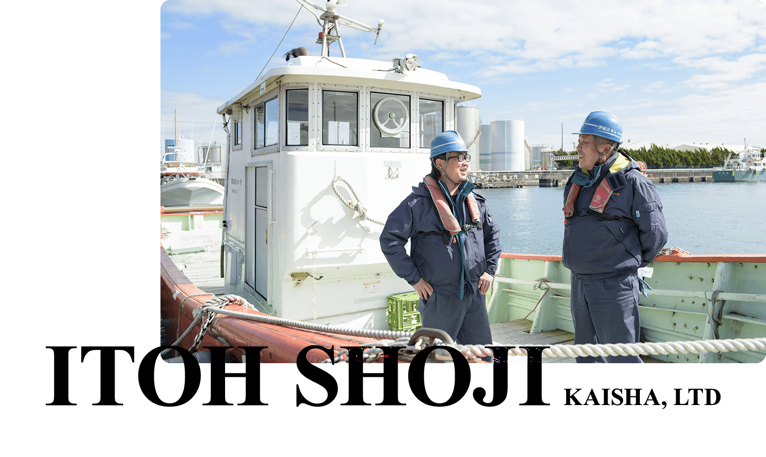 船の上でヘルメットを被った男性二人が笑顔で話している写真